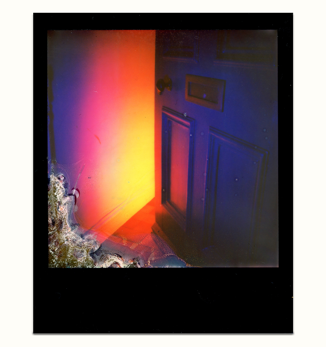 A scan of a black frame i-type Polaroid of A partially open purple door with amber yellow light radiating outwards from inside the home with a chemical burn in the lower left corner on a white background.